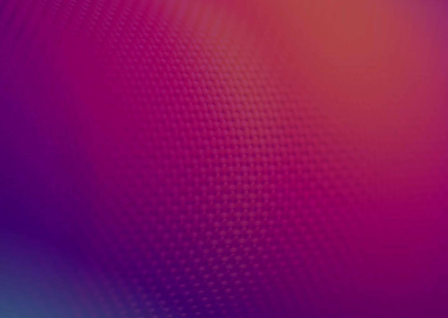 A roll of fabric bathed in orange, red, and purple light